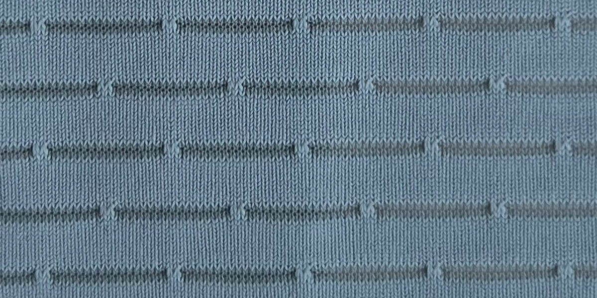 Close-up of Fractel Airline Mesh fabric, a blue-grey linear knit with open airflow channels